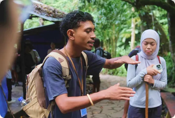Marselino guiding a traveller along a forest trail
