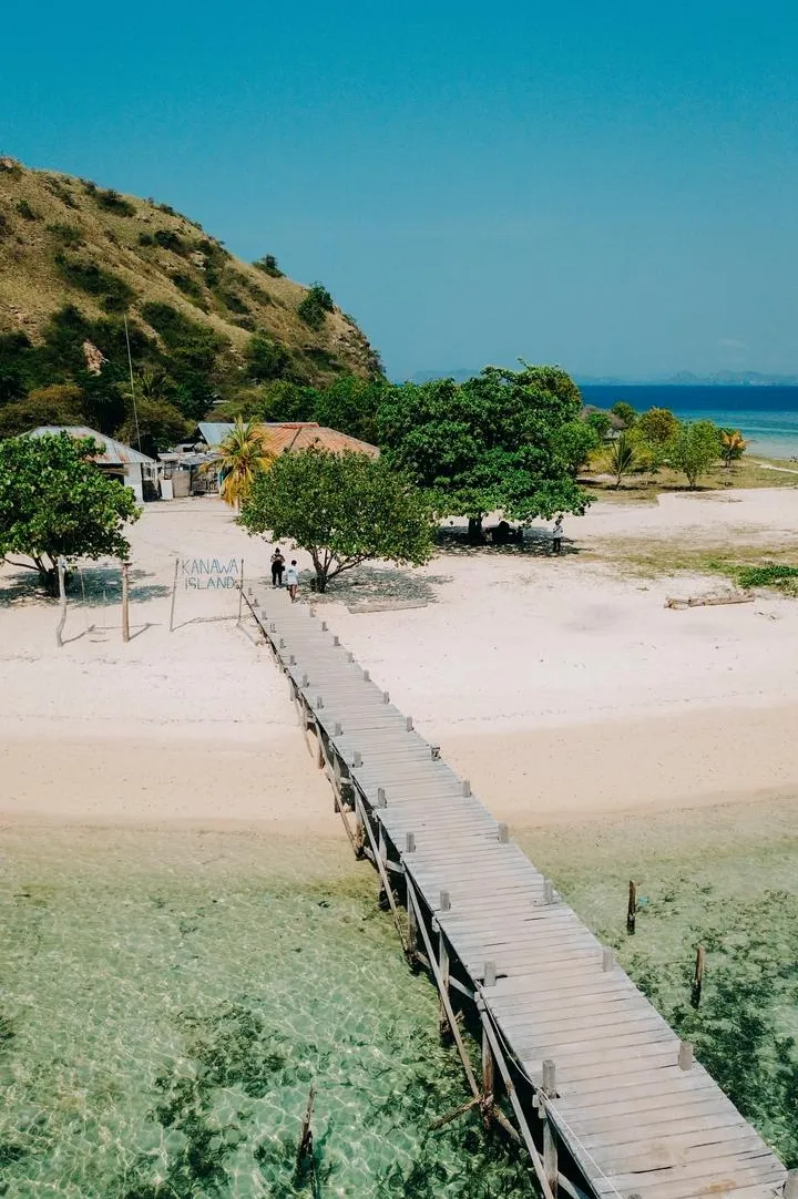 A wooden jetty reaching over a turquoise Flores bay