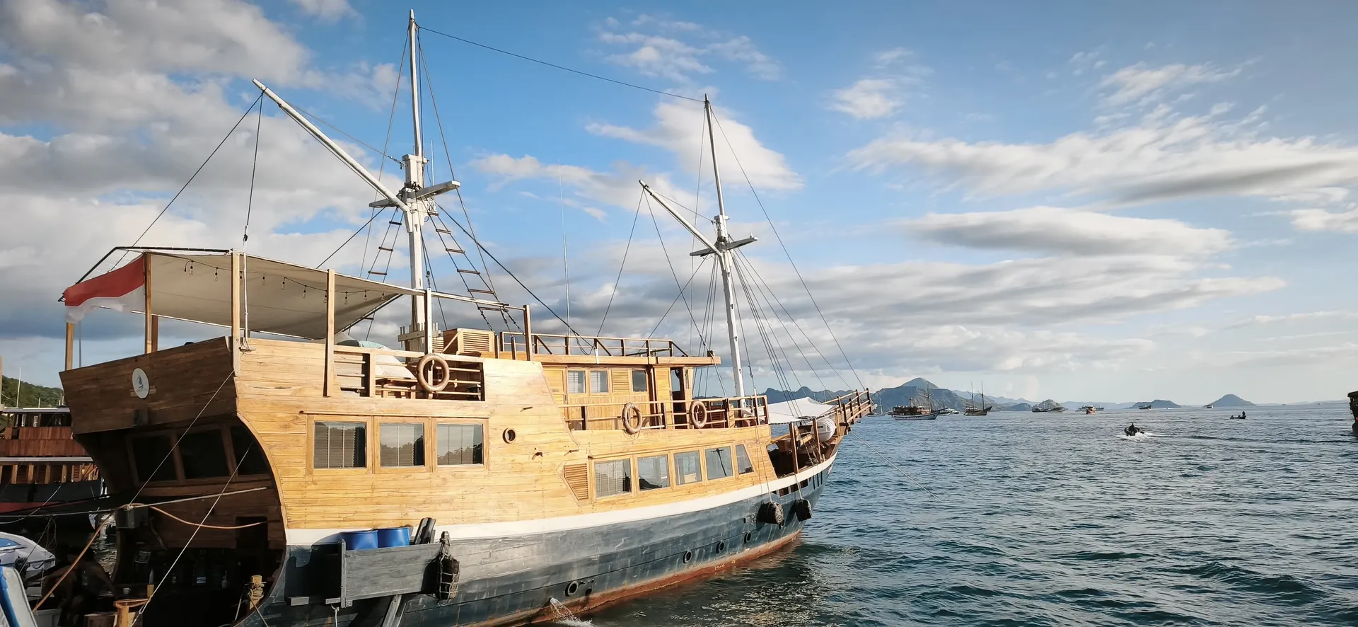 A traditional wooden phinisi boat anchored off the islands of Komodo