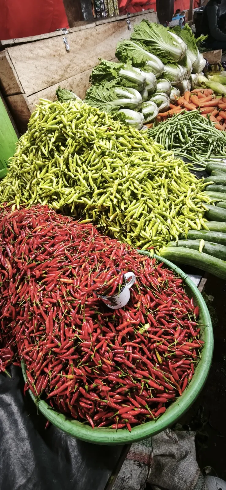 Baskets of fresh red chillies and vegetables at Ruteng local market