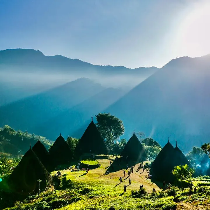 The cone-roofed houses of Wae Rebo among forested hills